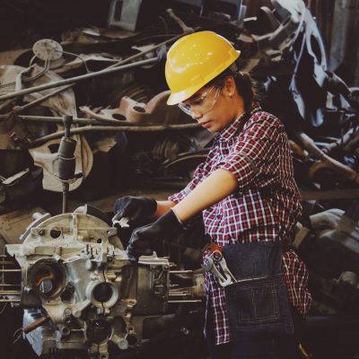 woman-wears-yellow-hard-hat-holding-vehicle-part-1108101